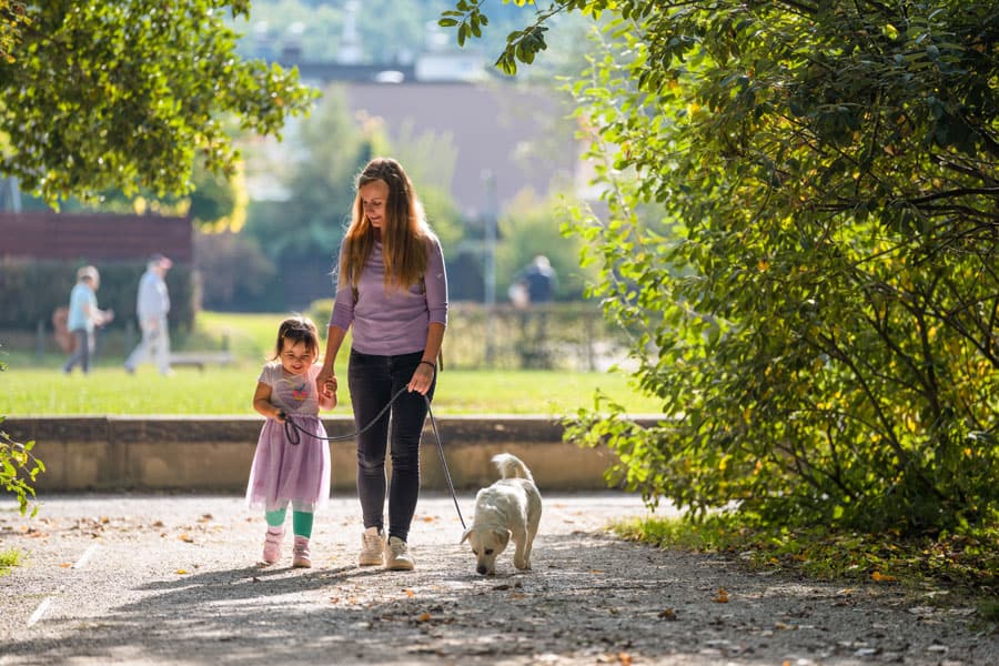 Une femme et un enfant promenant un chien